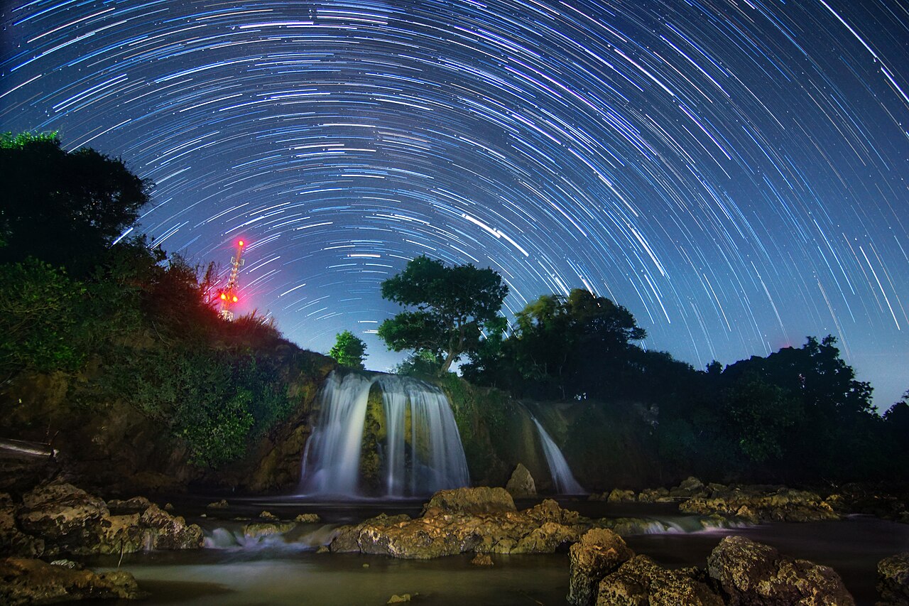 Jejak lingkaran bintang di langit malam di atas Air Terjun Toroan