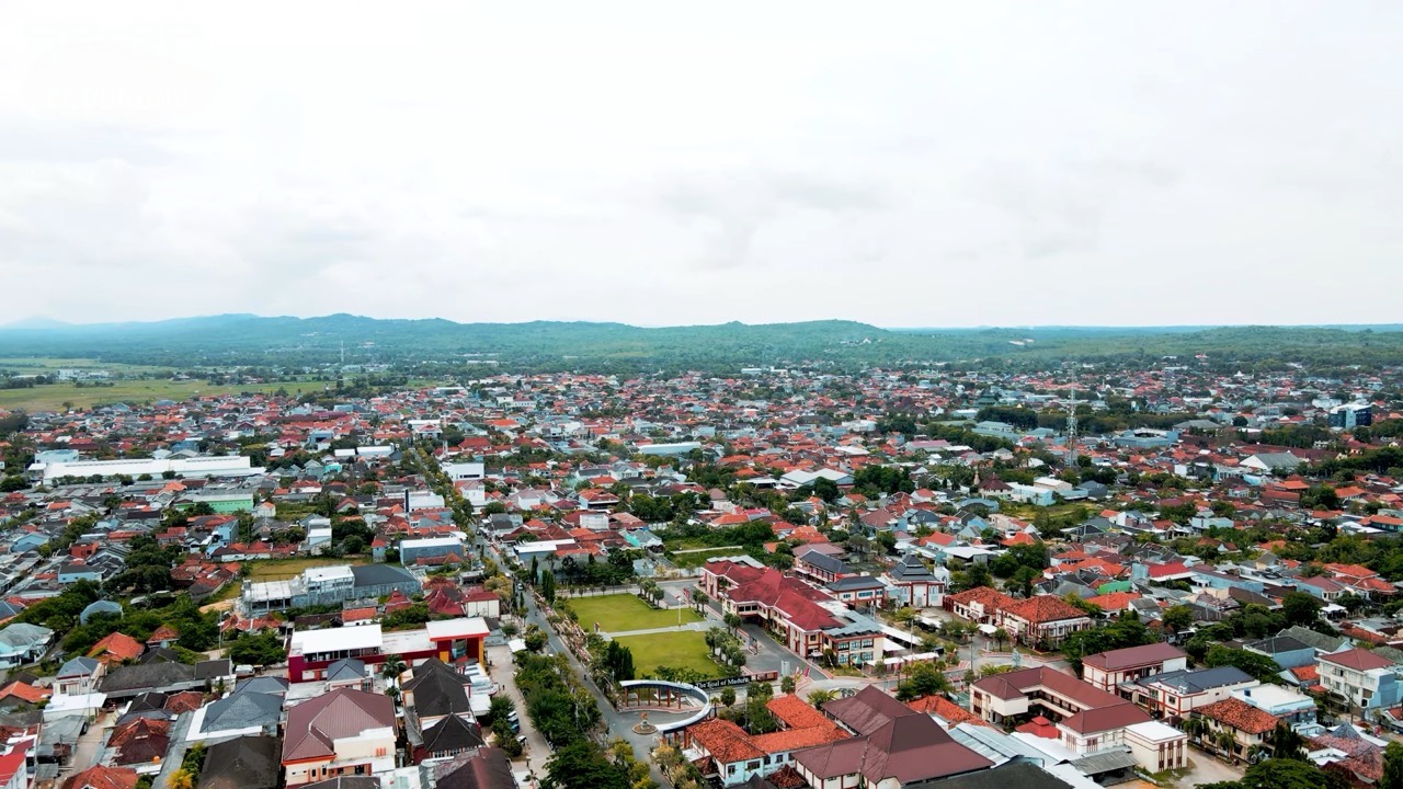 Kota Sumenep dilihat dari udara, atap-atap rumah rapat sampai ke kaki bukit di kejauhan