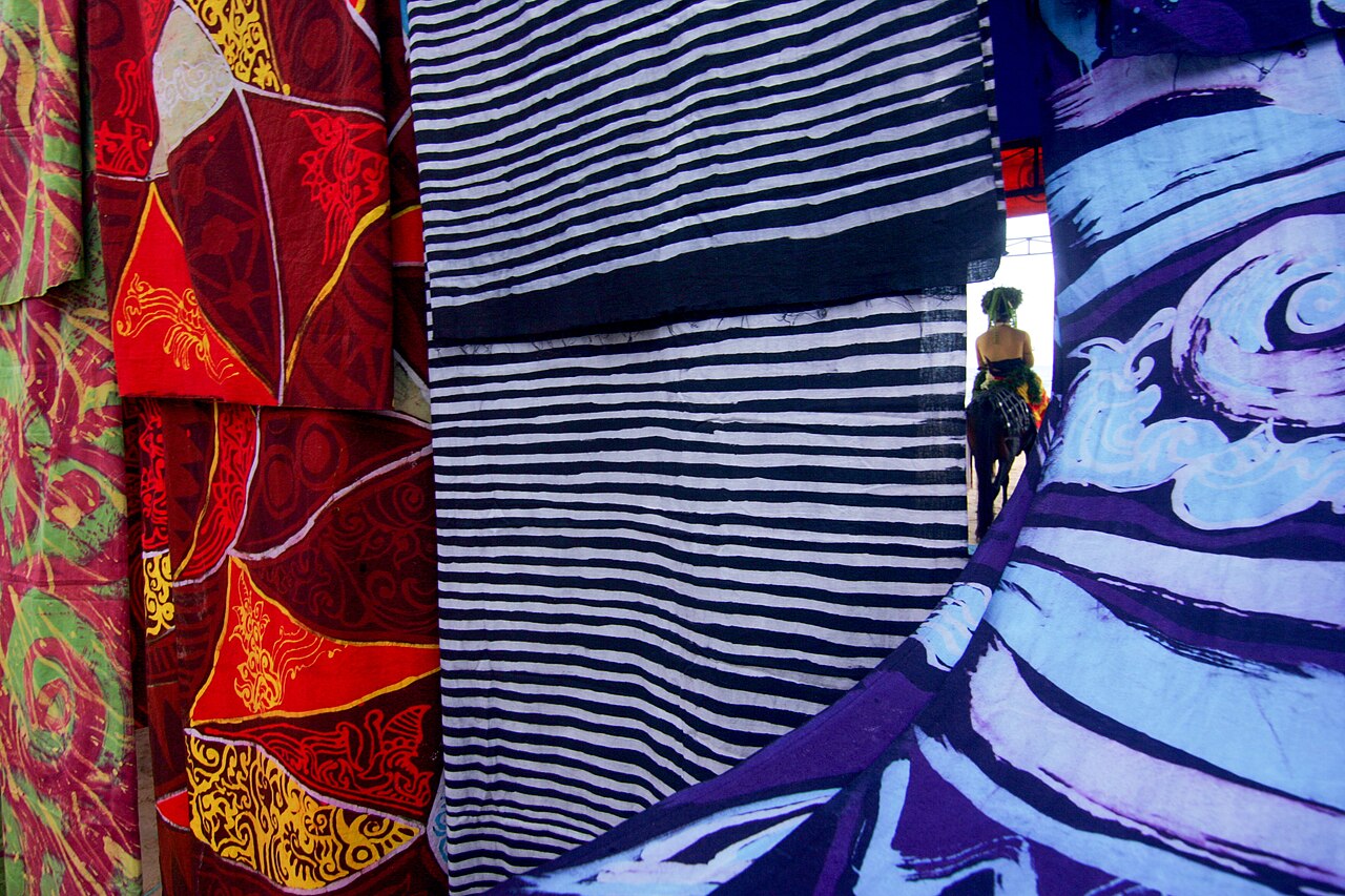 Beberapa lembar kain batik Madura tergantung berjajar dengan motif dan warna berbeda