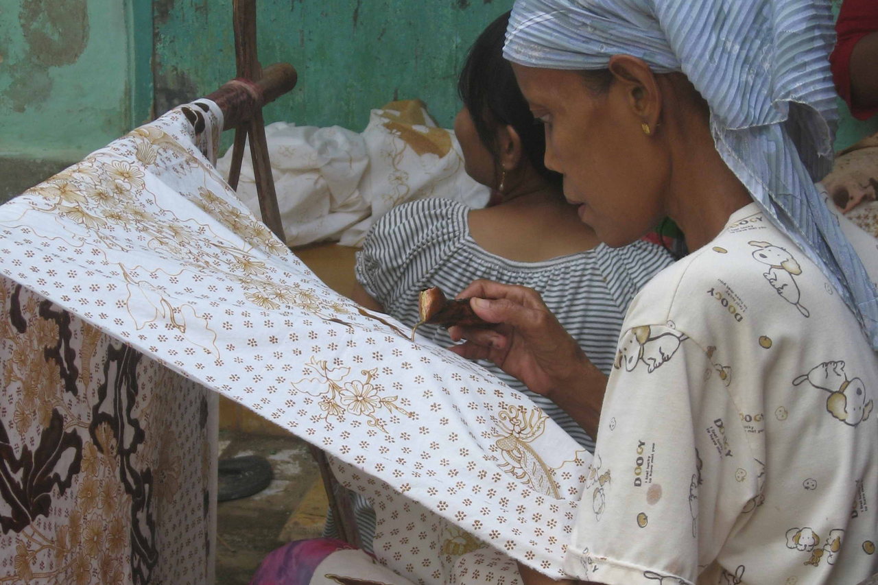 Perempuan pembatik di Tanjungbumi menggoreskan canting ke kain yang direntang di pangkuannya