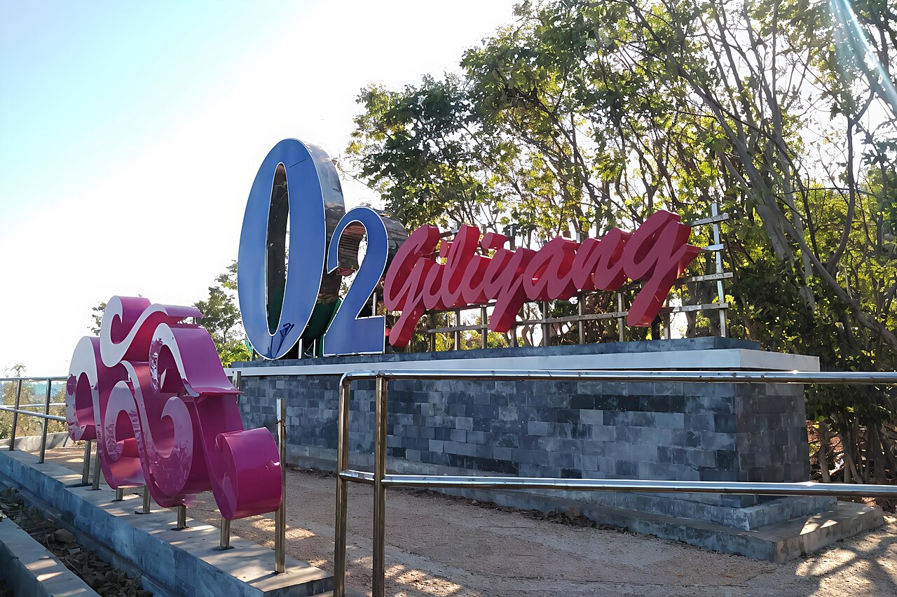 Tugu bertuliskan O2 Gili Iyang di tepi pantai pulau