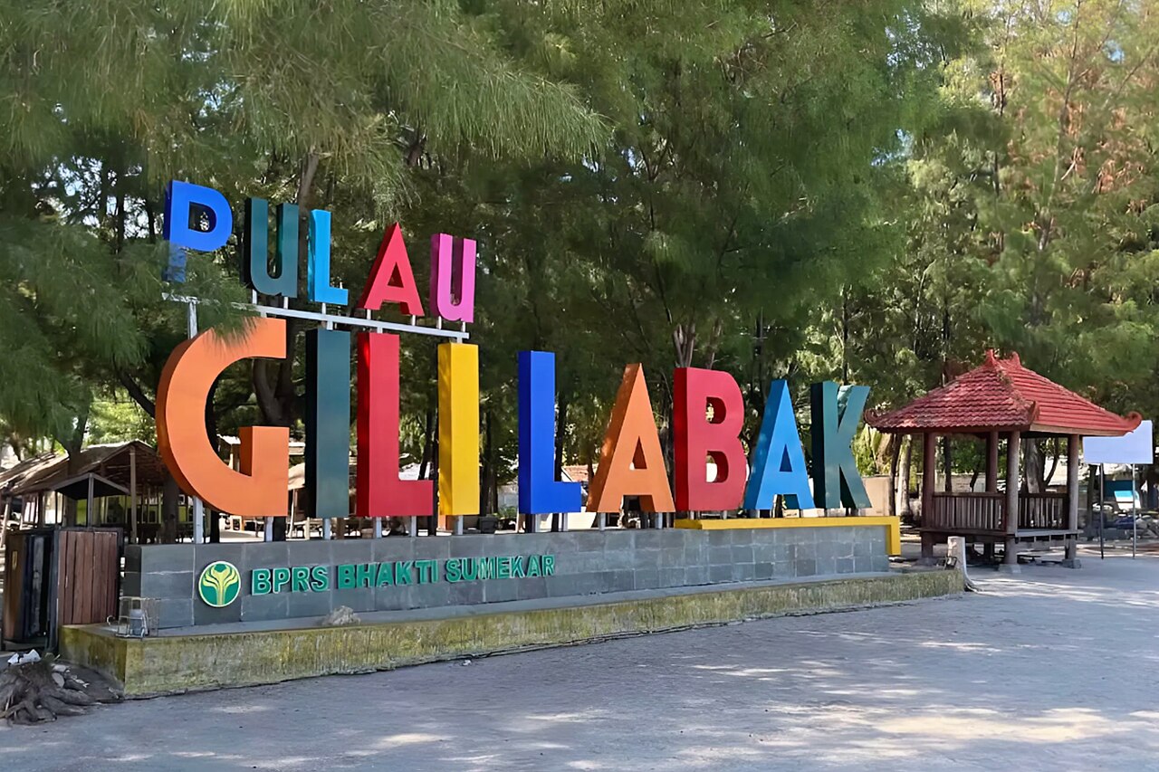 Tulisan Pulau Gili Labak berwarna-warni berdiri di tepi pantai pulau