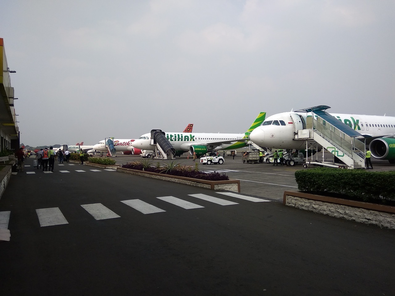 Gedung terminal Bandar Udara Halim Perdanakusuma di Jakarta dengan pesawat terparkir di apron