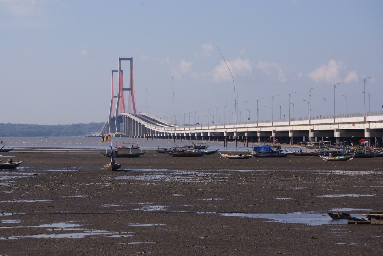 Jembatan Suramadu membentang di atas selat, dengan dua menara kabel penyangga di tengahnya