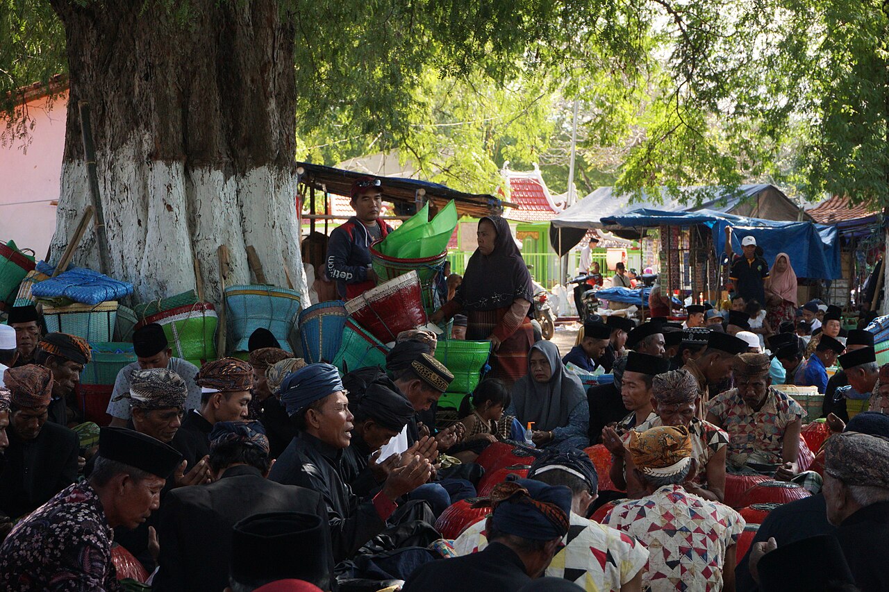 Warga berkumpul duduk di bawah pohon dalam upacara adat Nyadar