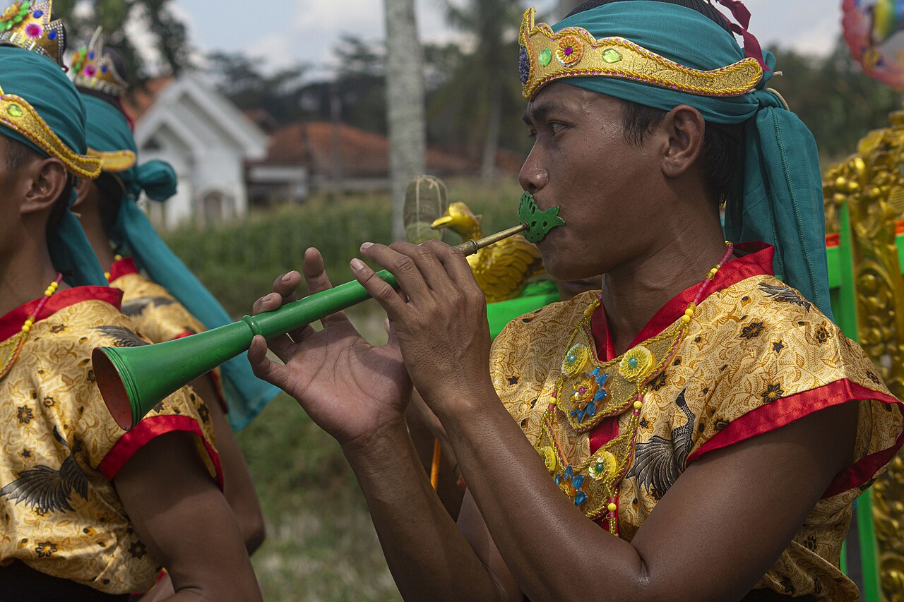 Seorang laki-laki meniup terompet kayu saronen